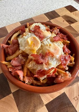 Una foto de Nido de patatas paja con huevos de codorniz y crujiente de jamón
