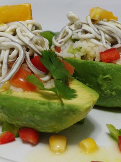 Una foto de Aguacates rellenos de pipirrana de arroz con vinagreta de naranja y gulas