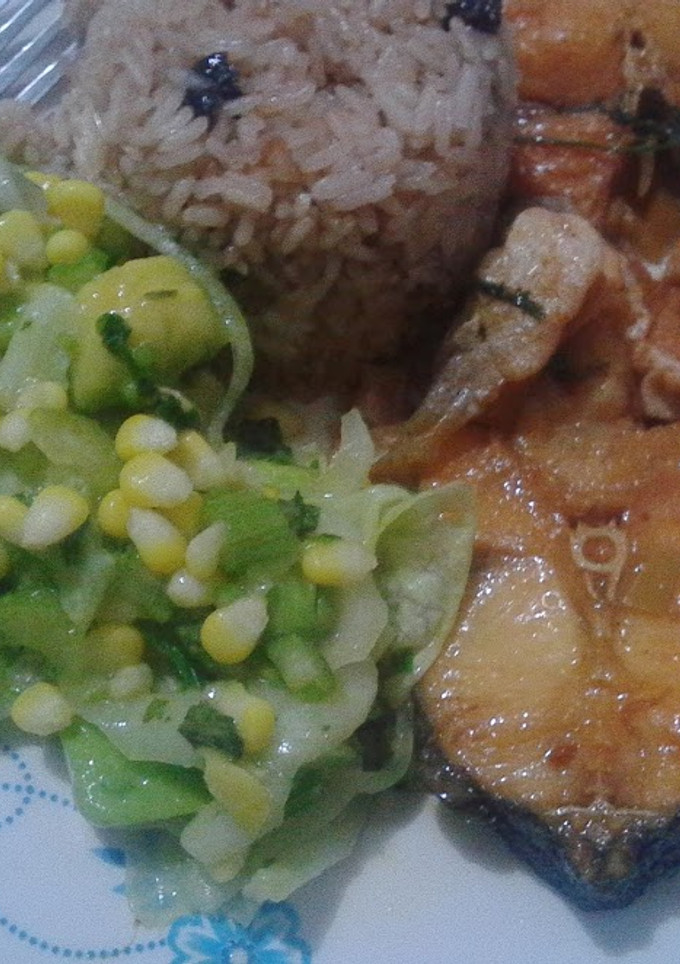Una foto de Pescado con coco, ensalada y arroz con uvas pasas