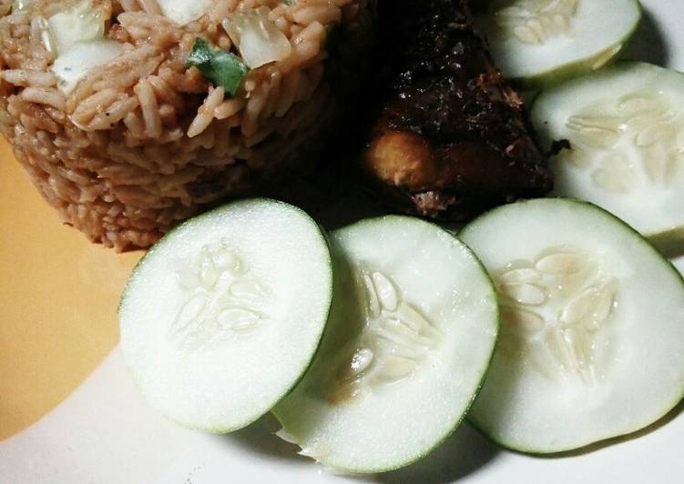 Turmeric jollof rice with cucumber and fried fish