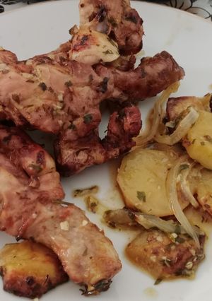 Una foto de Muslos asados de pollo con patatas panaderas