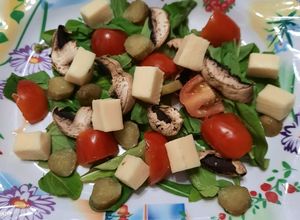 Una foto de Ensalada: rúcula, hongos, cherry, pepinillos y queso