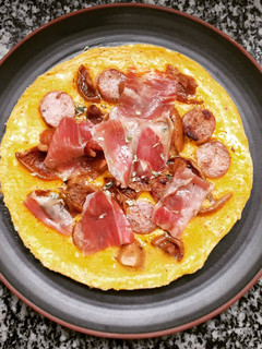 Una foto de Tortilla abierta de butifarra, rovellons y jamón
