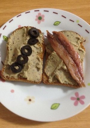 Una foto de Hummus con aceitunas negras