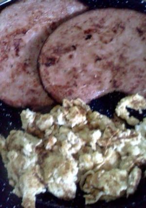 A picture of ham Steaks and scrambled eggs.