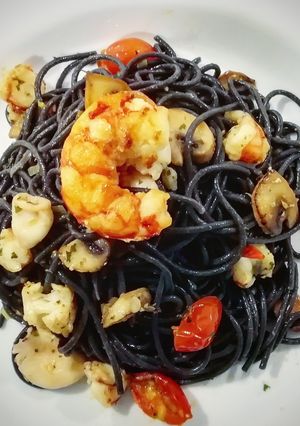 Una foto de Spaghetti de sepia con gambas, chipirones y cherry