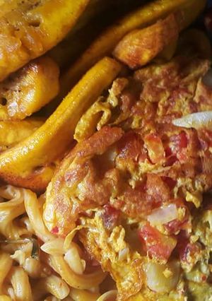 A picture of Macroni with fried plantain and fried egg.