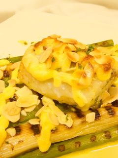 Una foto de Bacalao calçots y espárragos con alioli gratinado