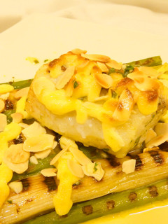 Una foto de Bacalao calçots y espárragos con alioli gratinado