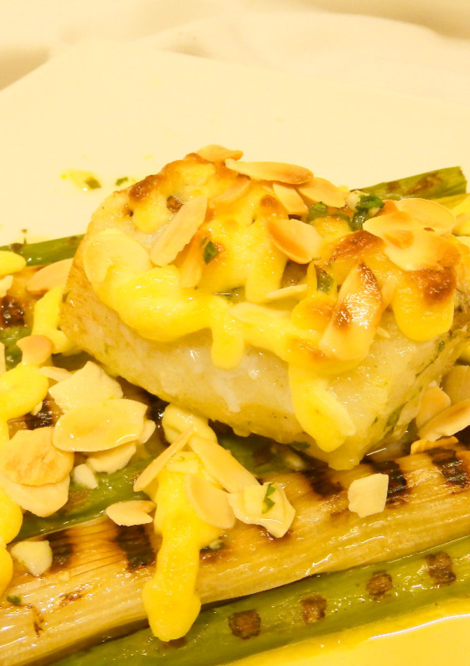 Una foto de Bacalao calçots y espárragos con alioli gratinado