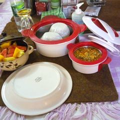 A picture of Tuwon shinkafa and egussi soup (broken rice meal) with fruit.