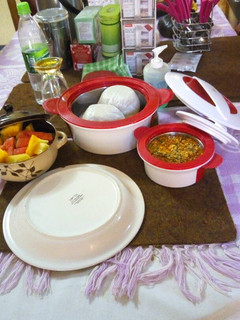 A picture of Tuwon shinkafa and egussi soup (broken rice meal) with fruit.