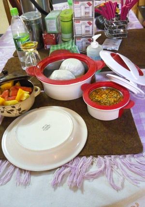 A picture of Tuwon shinkafa and egussi soup (broken rice meal) with fruit.