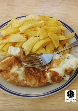 A picture of Chips with fried eggs.