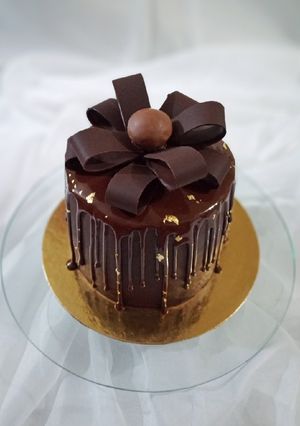 Una foto de Torta de trufa, ganache de chocolate blanco y brillo espejo