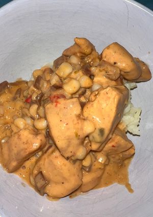 A picture of Queso chicken with corn and side of rice.