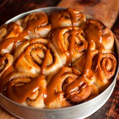 A picture of Cinnamon buns drizzled with warm caramel sauce.