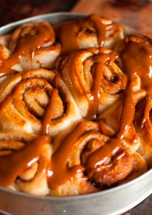 A picture of Cinnamon buns drizzled with warm caramel sauce.