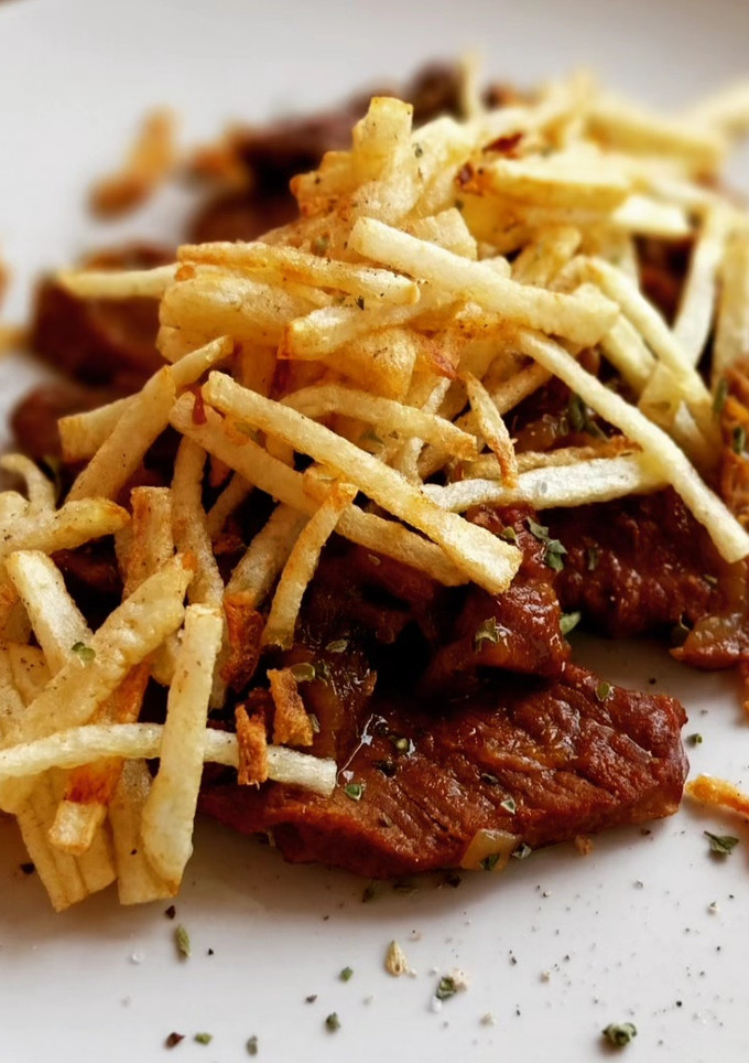 Una foto de Presa ibérica en salsa de Oporto con patatas paja