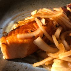A picture of Salmon with soy sauce and onion.