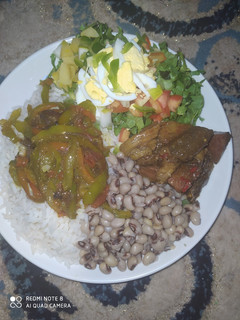 A picture of Rice and beans,salad,vegatable stir fry and beef sauce.