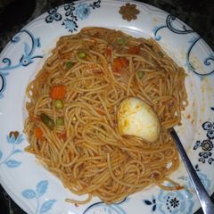 A picture of Spaghetti and egg + little veggies.