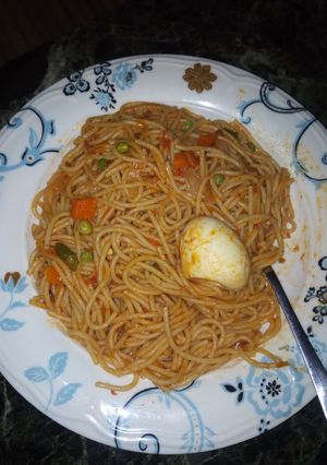 A picture of Spaghetti and egg + little veggies.