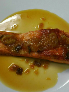 Una foto de Salmón con salsa reducida de cebolla, pimiento y mandarinas