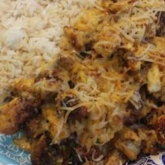 A picture of Teriyaki rice with bratwurst, potato, and scrambled eggs.