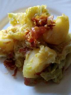 Una foto de Col con patatas al aroma de pimentón de La Vera, ajo y jamón