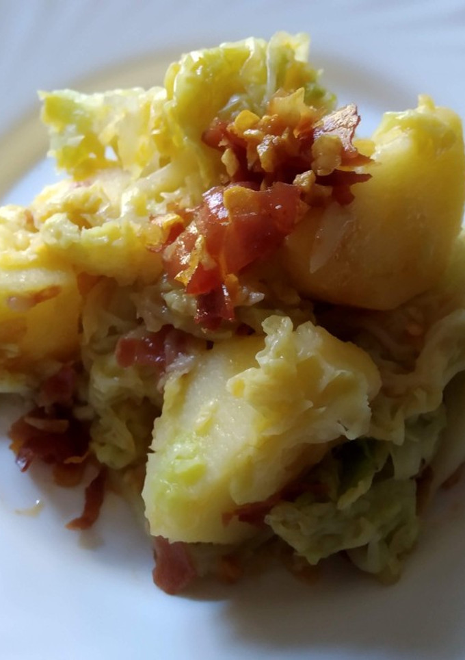 Una foto de Col con patatas al aroma de pimentón de La Vera, ajo y jamón