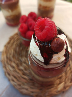 Una foto de Arroz con leche, bizcocho especiado, crema inglesa de chocolate negro y mermelada de frambuesas