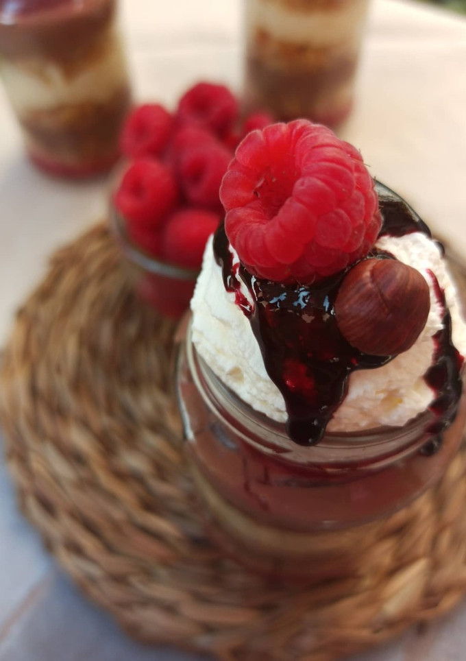 Una foto de Arroz con leche, bizcocho especiado, crema inglesa de chocolate negro y mermelada de frambuesas