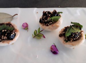Une photo de Champignons de Paris crus aux olives noires  graines de sésame et coriandre