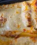Canelones rellenos de pechuga, salami genoa, tocineta y queso cheddar