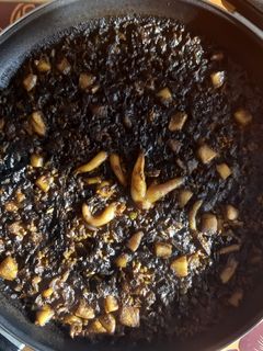 Una foto de Arroz negro de sepia con alioli