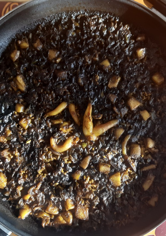 Una foto de Arroz negro de sepia con alioli