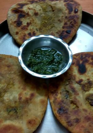 A picture of Achari Gobi ke parathe with green chutney.