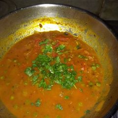 A picture of Tomato chutney with green peas.