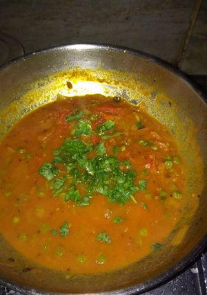 A picture of Tomato chutney with green peas.