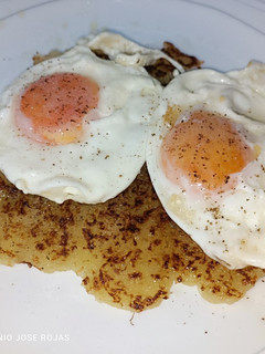 Una foto de Huevos fritos sobre torta de patata