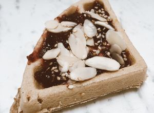Una foto de Waffle de yuca con mermelada de frutos rojos y almendras fileteadas