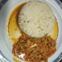 A picture of Spanish chicken with browned rice.