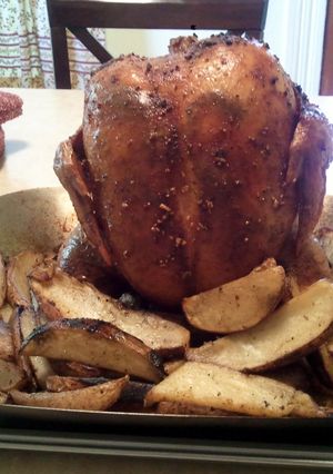 A picture of Smoky Beer Can Chicken with Potato Wedges.
