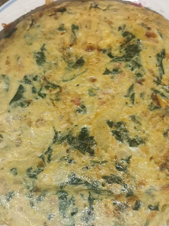 Una foto de Tortilla de patatas con espinacas, piñones y jamón