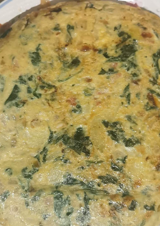 Una foto de Tortilla de patatas con espinacas, piñones y jamón