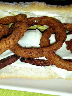 Una foto de Bocadillo de panceta y aros de cebolla