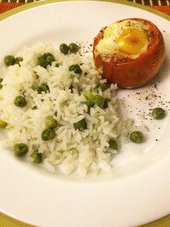 Una foto de Tomate relleno al horno con huevo y mozzarella, acompañado de arroz arvejado