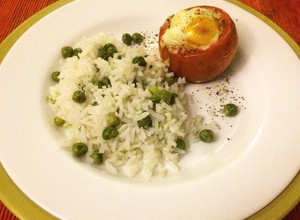 Una foto de Tomate relleno al horno con huevo y mozzarella, acompañado de arroz arvejado