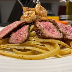 A picture of Surf n’ Turf over Garlic Basil Fettuccine.